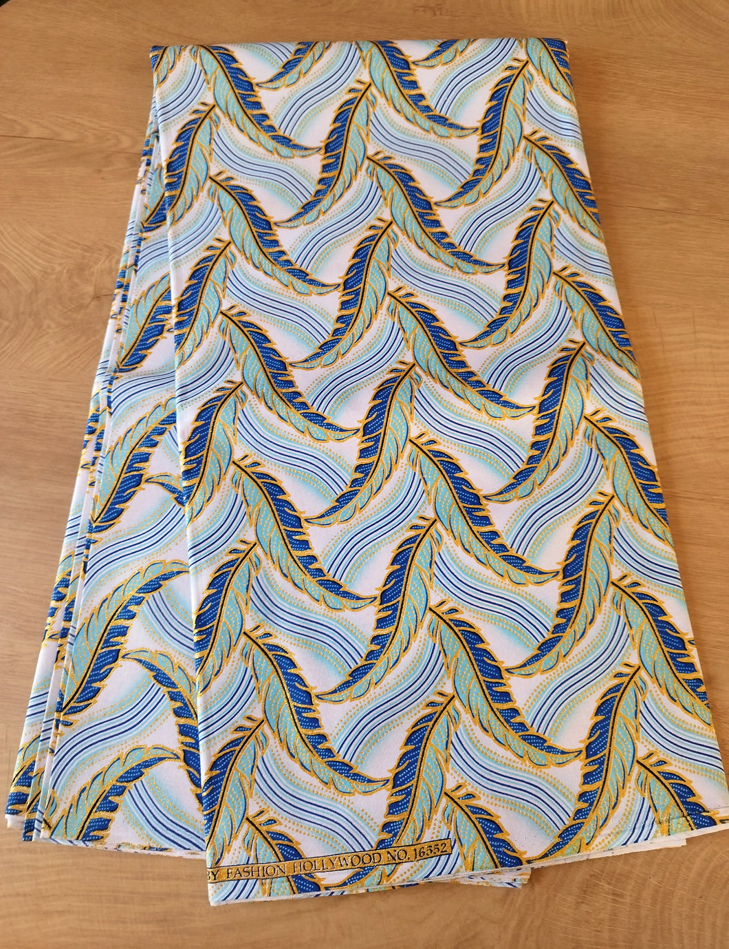 Tissu wax pailleté - plumes bleues et dorées fond blanc - par 50 centimètres