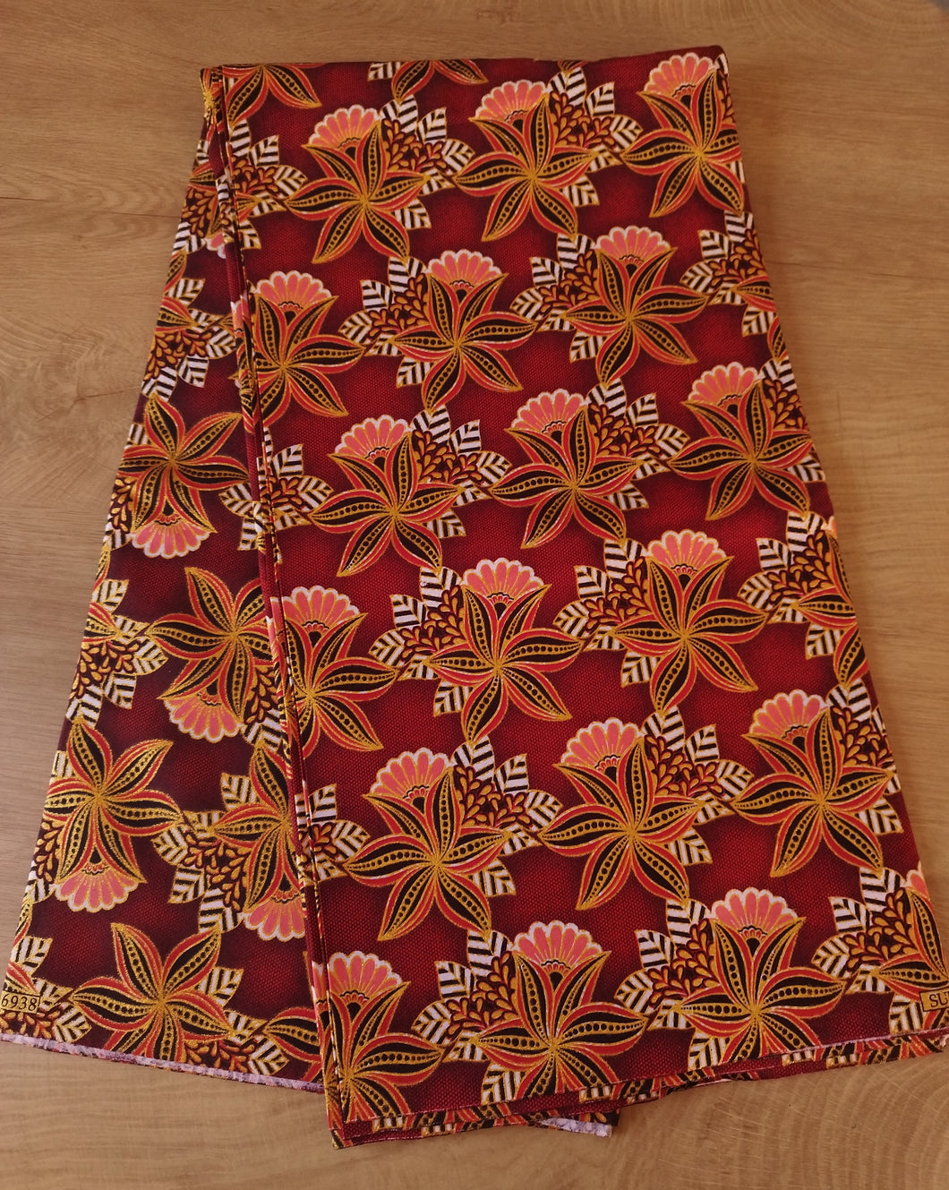 Tissu wax pailleté - petites fleurs corail et dorées fond rouge - par 50 centimètres