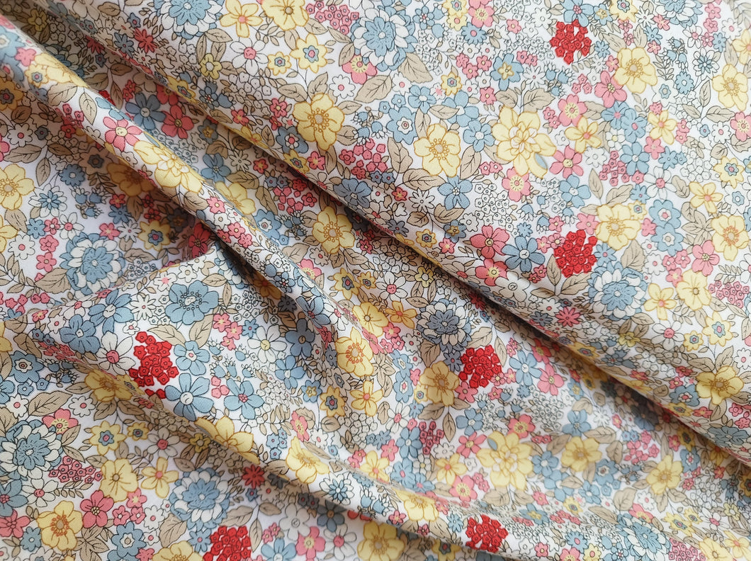 Tissu coton imprimé - petites fleurs bleues, jaunes et roses - par 50 cm