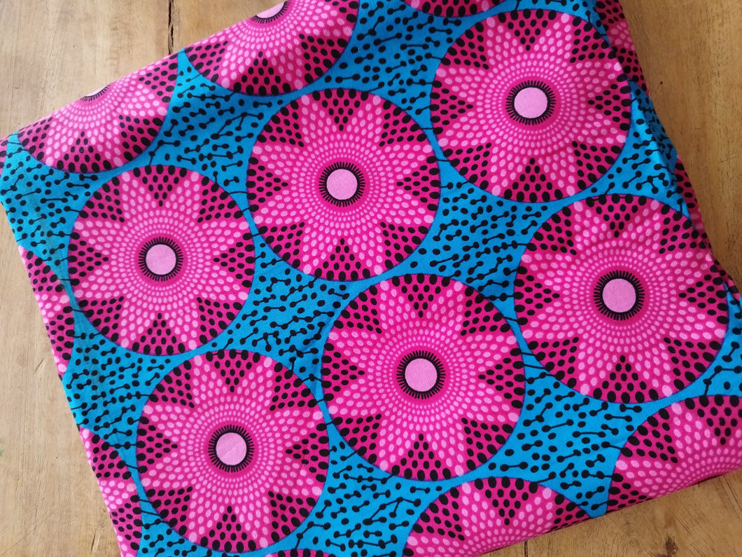Tissu wax - rosaces roses fond bleu - par 50 centimètres