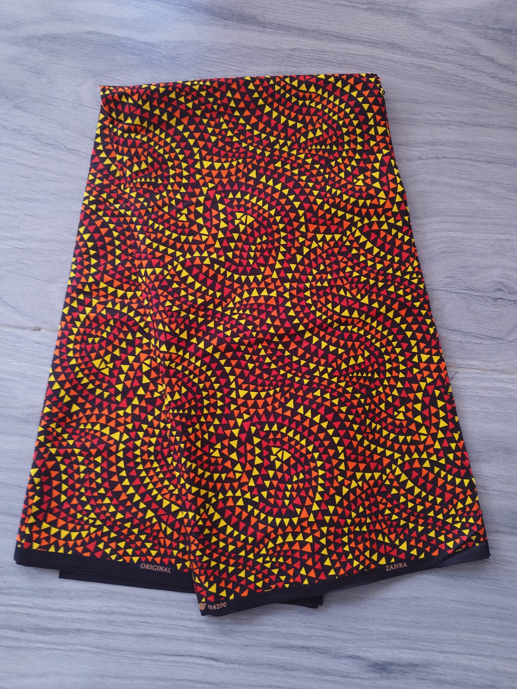 Tissu wax - petits triangles jaunes, oranges, rouges, noirs - par 50 centimètres